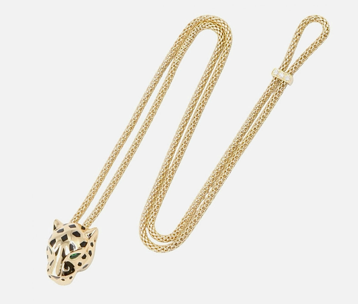 Gold-tone panther-head pendant necklace with openwork design and green eye accents